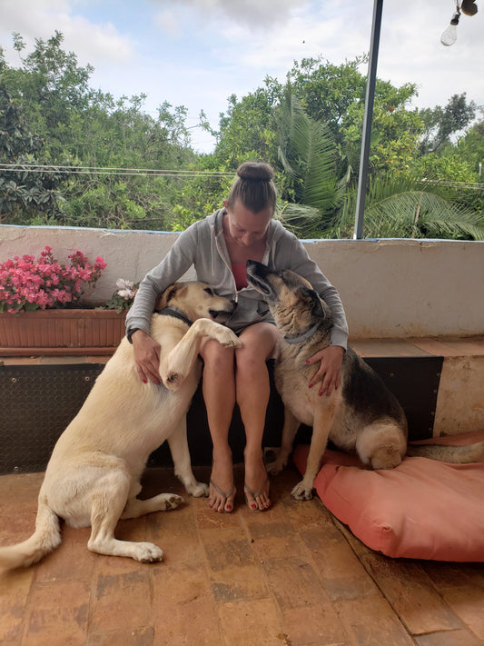 Jo sitting with her beloved pets Jessie and Bernie on a terrace, showing the deep bond between pets and their owners