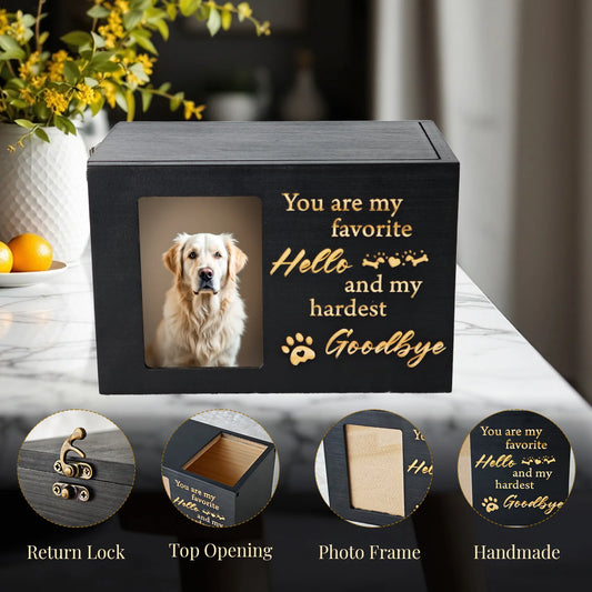 Black pet urn with a photo of a dog and engraved text on a marble surface.