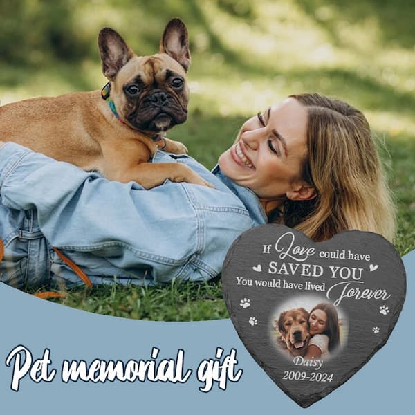 Woman lying on grass with a small dog, heart-shaped pet memorial gift in foreground