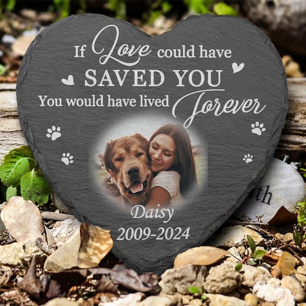 Heart-shaped slate plaque with a photo of a woman and her dog, and engraved text on a natural background.