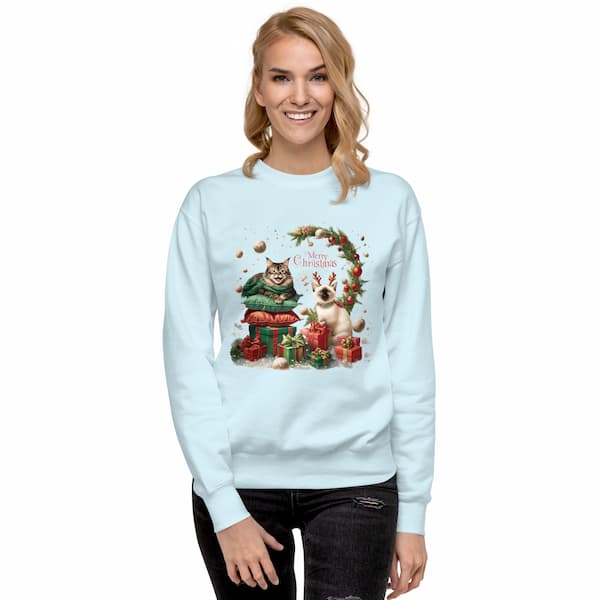 Woman wearing a light blue sweatshirt with a Christmas-themed design featuring a cat and dog.