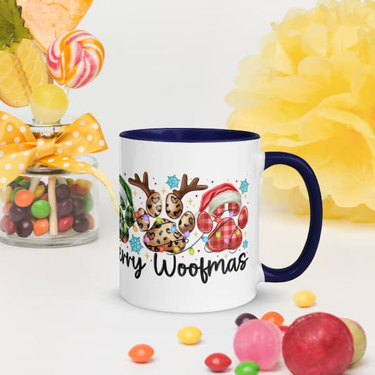 Mug with Christmas design featuring paw prints, reindeer, and Santa hat, surrounded by colorful candies and flowers.