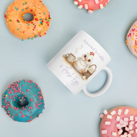 Cute chicken lover coffee mug with “Powered by Coffee & Fresh Eggs” design featuring an adorable hen, coffee cup and egg basket on a white ceramic mug.