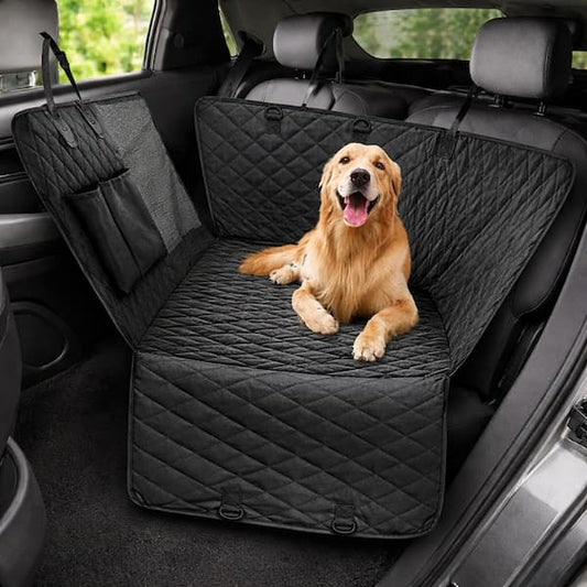 Dog sitting on a black car seat cover in a vehicle