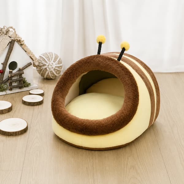 Snail-shaped pet bed on a wooden floor with decorative elements in the background