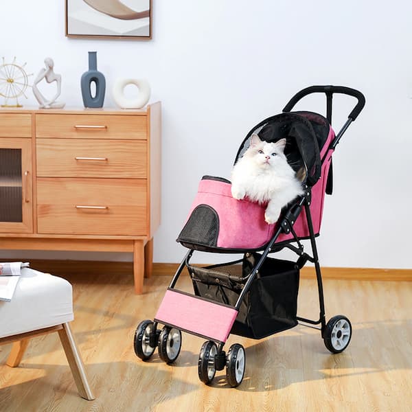 Pink Pet stroller with a cat inside in a room setting