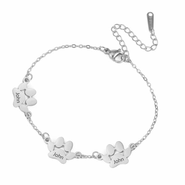 Silver bracelet with paw print charms and 'John' engraving on a white background