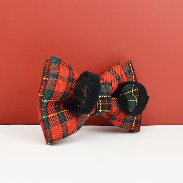 Plaid bow tie with black accents on a white surface against a red background