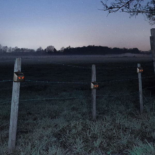solar animal deterrent device with red lights designed to help deter predators and protect chickens and garden areas at night