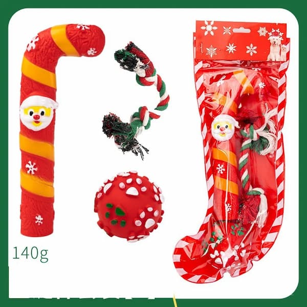 Dog toys including a candy cane, ball, and stocking with Santa Claus design on a white background.