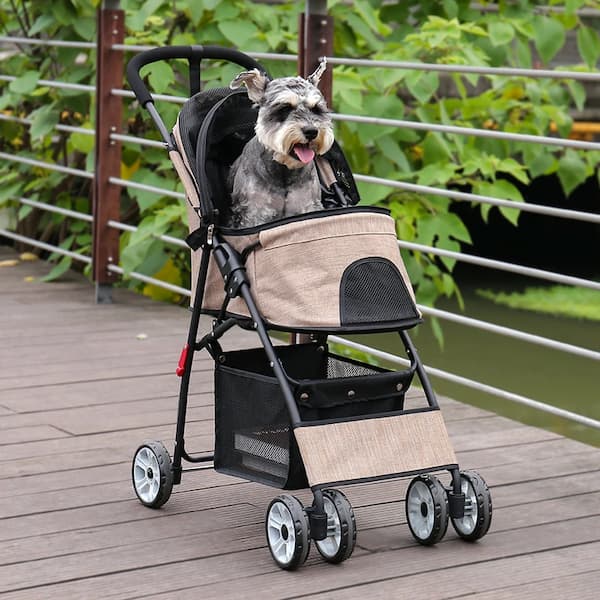 Dog in a pet stroller on a wooden deck with greenery in the background