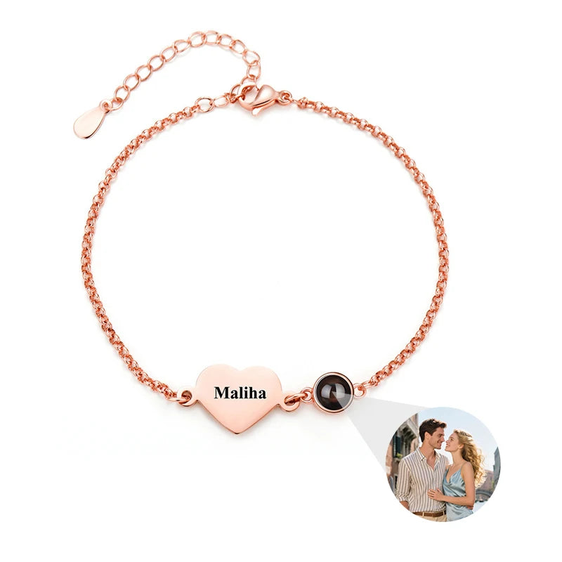 Rose gold bracelet with heart-shaped name tag and photo charm on a white background