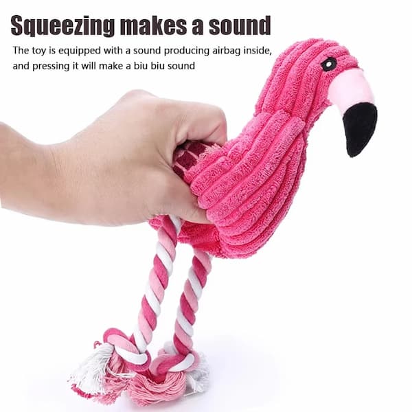 Pink flamingo toy with a rope, held by a hand, on a white background.