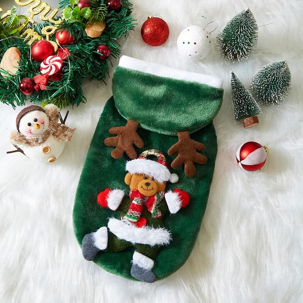 Green Christmas pet hoodie with a teddy bear design surrounded by festive decorations on a white surface.