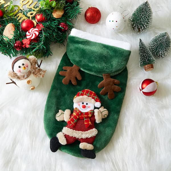 Green Christmas pet hoodie with Santa Claus design surrounded by festive decorations on a white surface.