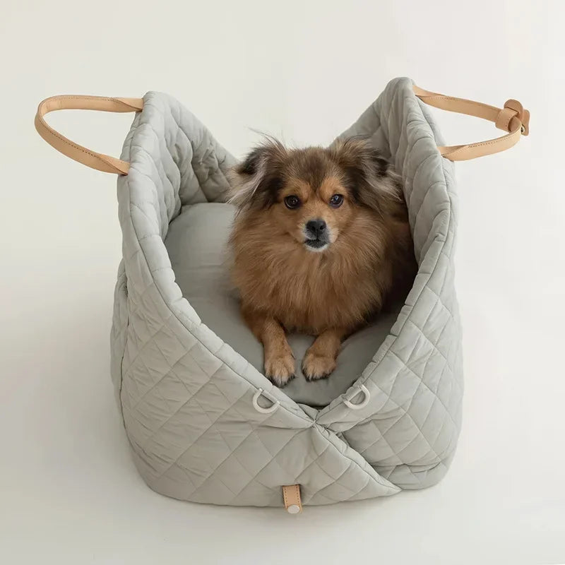 Dog sitting comfortably in luxury pet tote booster seat on a summer road trip