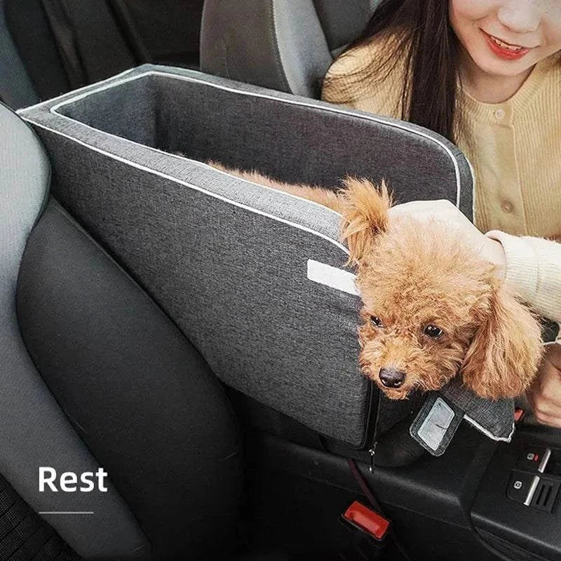 Gray portable dog car seat bed with a small dog inside, secured by adjustable straps in a car.