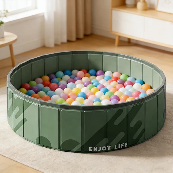 Green pet playpen with colorful balls inside, labeled 'ENJOY LIFE', on a carpeted floor.