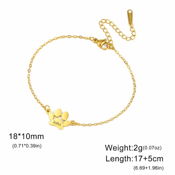 Gold bracelet with paw print charm and 'John' engraving on a white background