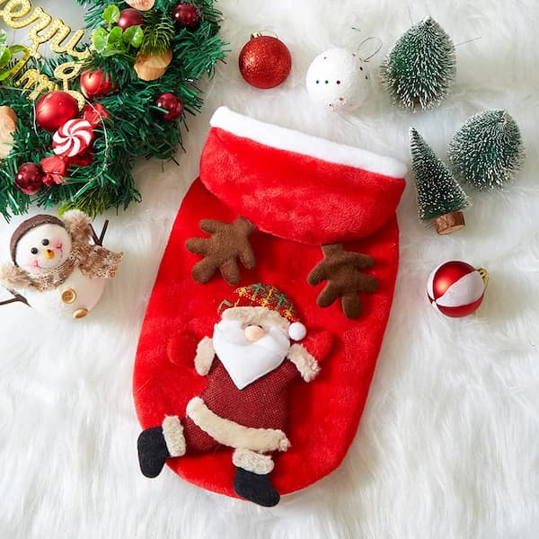 Red Christmas pet hoodie with Santa Claus figure surrounded by festive decorations on a white surface.