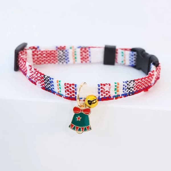 Colorful patterned cat collar with a bell and small charm on a white background