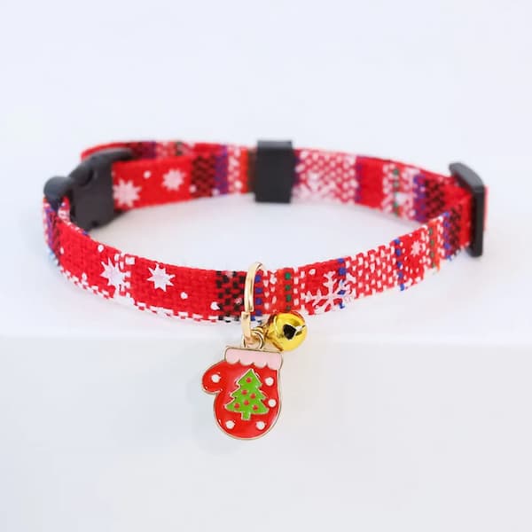 Red and white patterned cat collar with a Christmas-themed tag and bell on a white background
