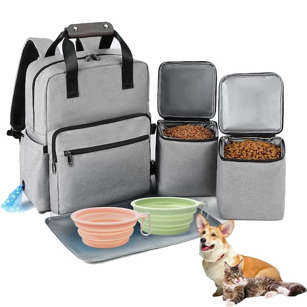 Gray pet travel backpack with food containers, a pink bowl, and a green bowl on a white background.