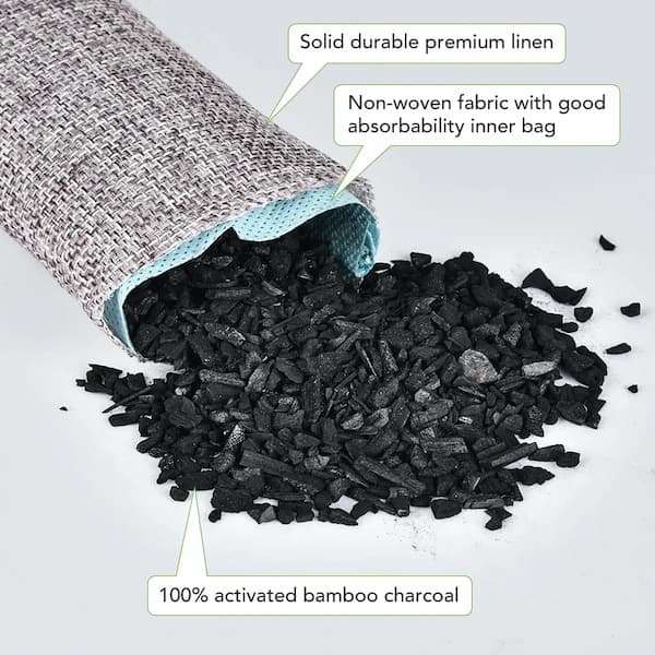 Black activated bamboo charcoal spilling out of a gray and green fabric bag on a white background.