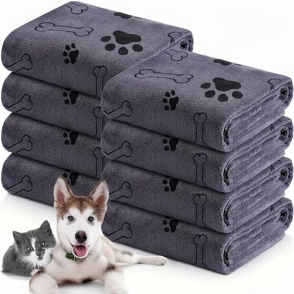 Stack of gray pet towels with paw and bone designs, featuring a dog and cat on a white background.