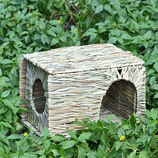 Foldable woven grass rabbit cage with chew toy mat for small animals.