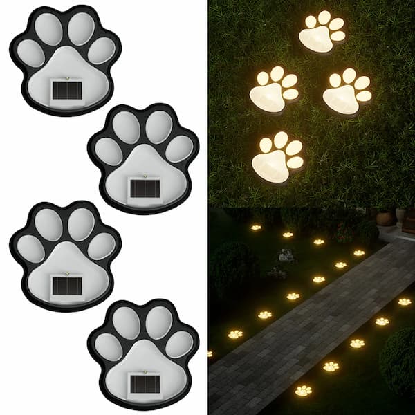 Solar-powered paw-shaped lights on a white background with an example of installation on a garden path.