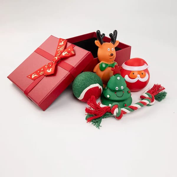 Red gift box with Christmas-themed toys on a white background