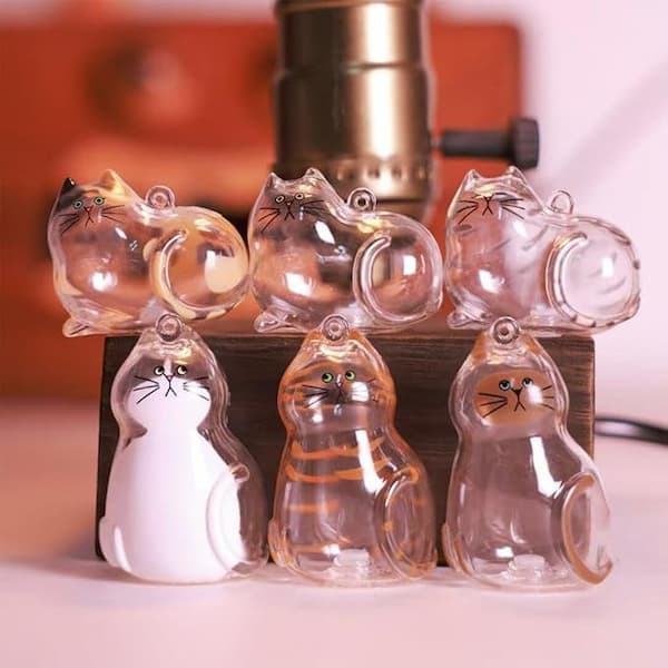 Clear cat-shaped objects with black outlines on a wooden stand.