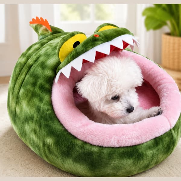 Small white dog in a green dinosaur-shaped pet bed with a pink interior.