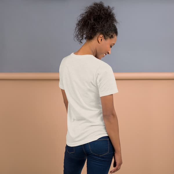 Person wearing a white t-shirt with a logo on the back, standing against a neutral background.