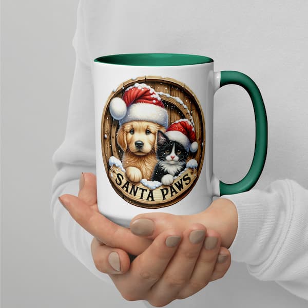 Mug with a design of a dog and cat wearing Santa hats, labeled 'Santa Paws', held by a person.