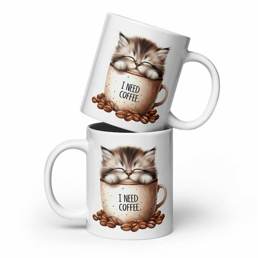 Two white mugs with a cat illustration and 'I Need Coffee' text, stacked on a white background.